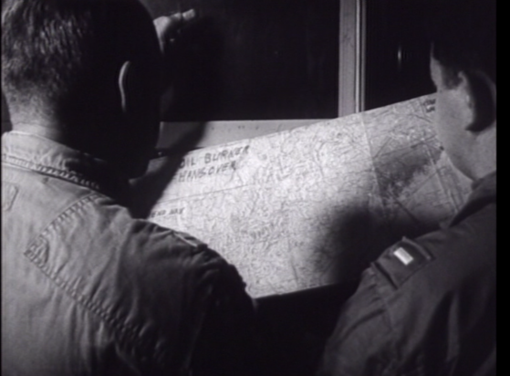 footage from a DVD in Chicopee library history room, westover Air Force Base section, marked Disk 1. In screenshiot two soldiers appear to be reviewing a map. In top left corner of the map it says something like 