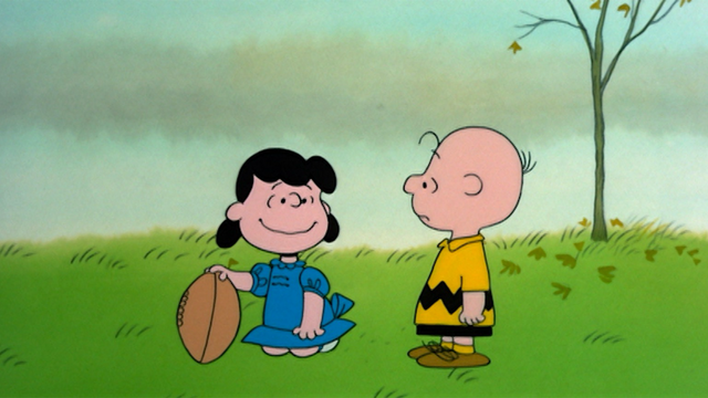 Lucy holds the football for Charlie Brown to kick. Schultz’s popular device that revisits the themes of hope, faith and betrayal. 