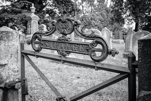 A gate marker on the Strange family plot in the Sleepy Hollow Cemetery, in stark black and white textures 