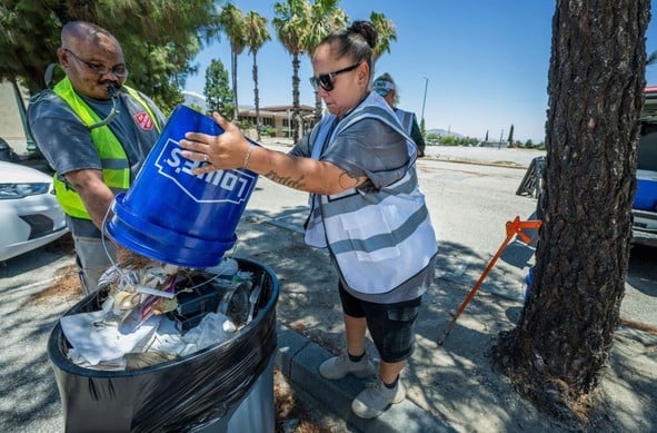 From left, Josh Hunter and Jessica Lopez, who are both without permanent shelter, work in the Riverside County Fifth District Homeless to Work Program as they clean up a parking lot in Banning on Friday, July 19, 2024. (Photo by Terry Pierson, The Press-Enterprise/SCNG)