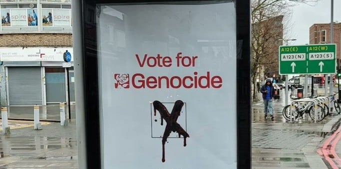 sign on bus stop, vote for genocide, with dripping X in box